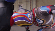 a man in a colorful superhero costume is kneeling on the ground