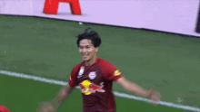 a soccer player wearing a red and white jersey with a red bull on it
