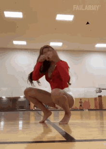 a woman squatting on a basketball court with failarmy on the bottom right