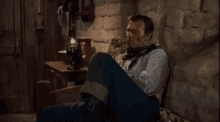 a man is sitting on a couch smoking a pipe