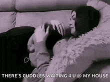 a man and a woman are laying on a couch and hugging .