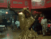 a man in a gold dress is dancing in a room with numbers 0 and 0 on the walls