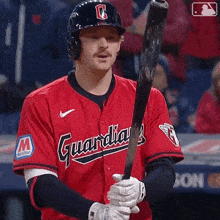 a man in a red guardians jersey holding a bat