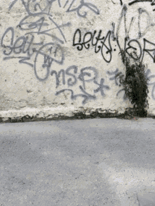 a white wall with graffiti on it including the word jesus on it