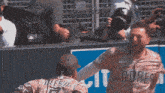 a man wearing a padres jersey is being congratulated by another player