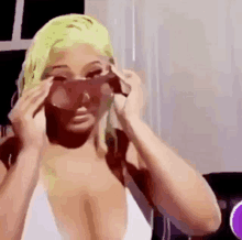 a woman is wearing sunglasses and a white bikini top .