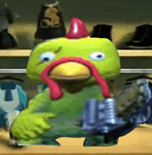 a green stuffed animal with a red hat and a chicken neck