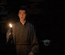 a man is holding a torch in the dark