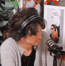 a woman wearing headphones sitting in front of a microphone