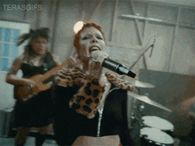a woman singing into a microphone with the words terasgifs written on the bottom