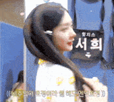 a woman holds her hair in front of a sign that says 서희