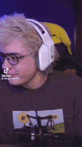 a man wearing glasses and headphones is sitting in a chair .