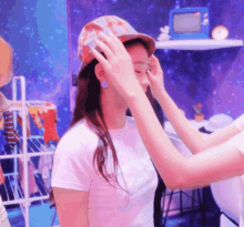 a woman wearing a hat is being helped by another person