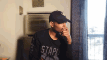 a man wearing a black shirt that says " stapl " on it