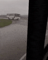 a bus is driving down a road in the rain