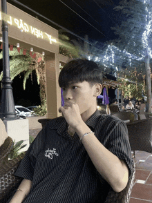 a young man sitting in front of a building that says " y "