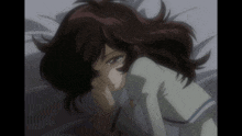 a girl with dark hair is laying on a bed with her hand on her face