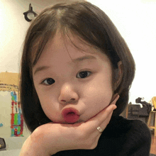 a little girl with a ring on her finger making a funny face