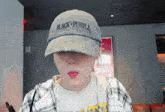 a woman wearing a hat that says black and purple