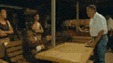 a group of men standing around a table with a sign in the background that says ' ao ' on it