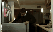 a man opens a refrigerator door in a kitchen with a sticker on the door that says " i love you "