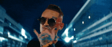 a man with sunglasses and a tattoo on his face