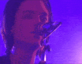 a man singing into a microphone in a dark room