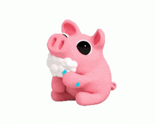 a pink pig is holding a piece of cotton in its paws .