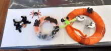 a wreath with spiders bats and ghosts on it is on a table