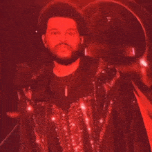 a man with a beard is wearing a sequined jacket and a necklace .