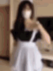 a woman wearing a mask and an apron is taking a selfie .