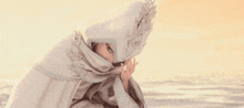 a cartoon character is wearing a white cape with a hood and a crown on her head .