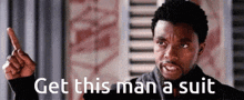 a man is pointing up with the words `` get this man a suit '' written below him .
