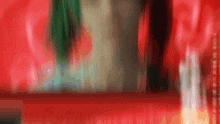 a blurry picture of a person standing in front of a red wall .