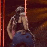 a woman wearing a bandana is dancing on a stage in front of a crowd .