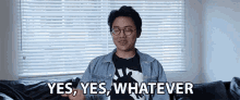 a man sitting on a couch with the words yes yes whatever behind him