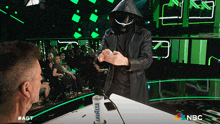 a man in a hooded jacket stands in front of a lavabella cup