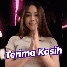 a woman in a white shirt is giving a thumbs up with the words terima kasih below her