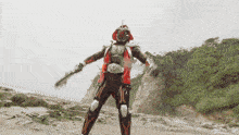 a man in a superhero costume is standing on a rocky beach holding a gun