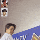 a man is standing in front of a sign that says ' votv '