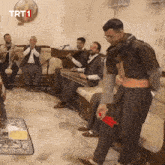 a group of men are playing instruments in a room with trt1 on the wall
