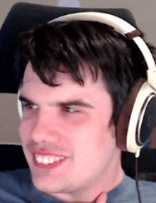 a man wearing headphones is smiling and making a face