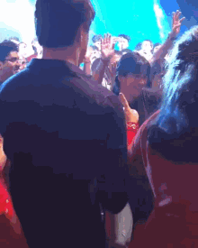 a man in a black shirt is standing in the middle of a crowd of people
