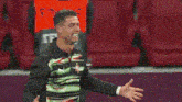 a man is covering his face with his hand while another man hugs him .