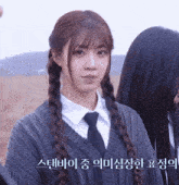 a girl wearing a sweater and tie with korean writing on the bottom