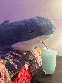 a stuffed shark is drinking from a mason jar that says max