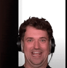 a man is wearing headphones and smiling for the camera