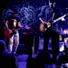 a man in a hat is playing a guitar on a stage with a purple background and the words @johnnydepp_gifs