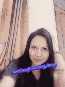 a woman taking a selfie with the words one lagi karang dong