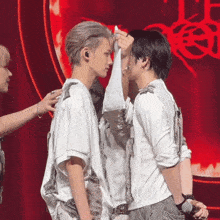 a couple of men standing next to each other on a stage with a red background